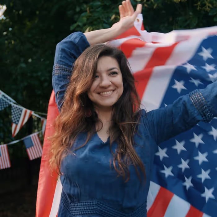 A smiling woman holding an American flag